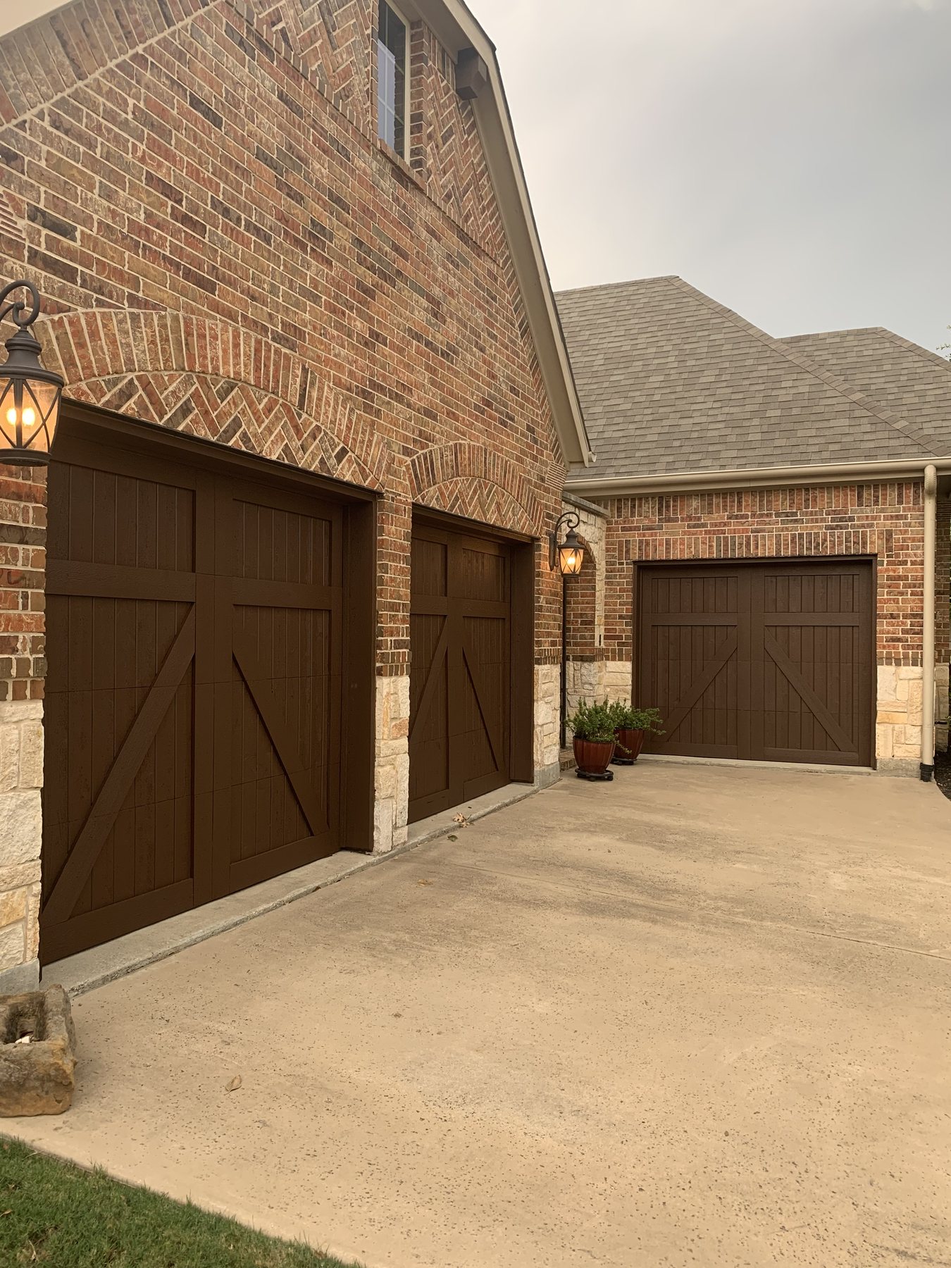 Three walnut garage doors on a white estate